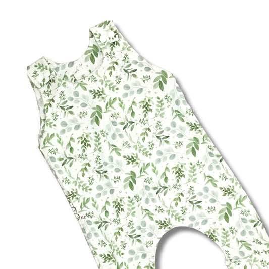 Long romper for baby and toddler girls with a watercolor green leaves print on a white background